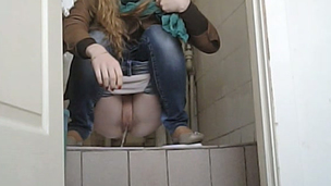 Youthful blondie pulls down her jeans and pisses in the toilet
